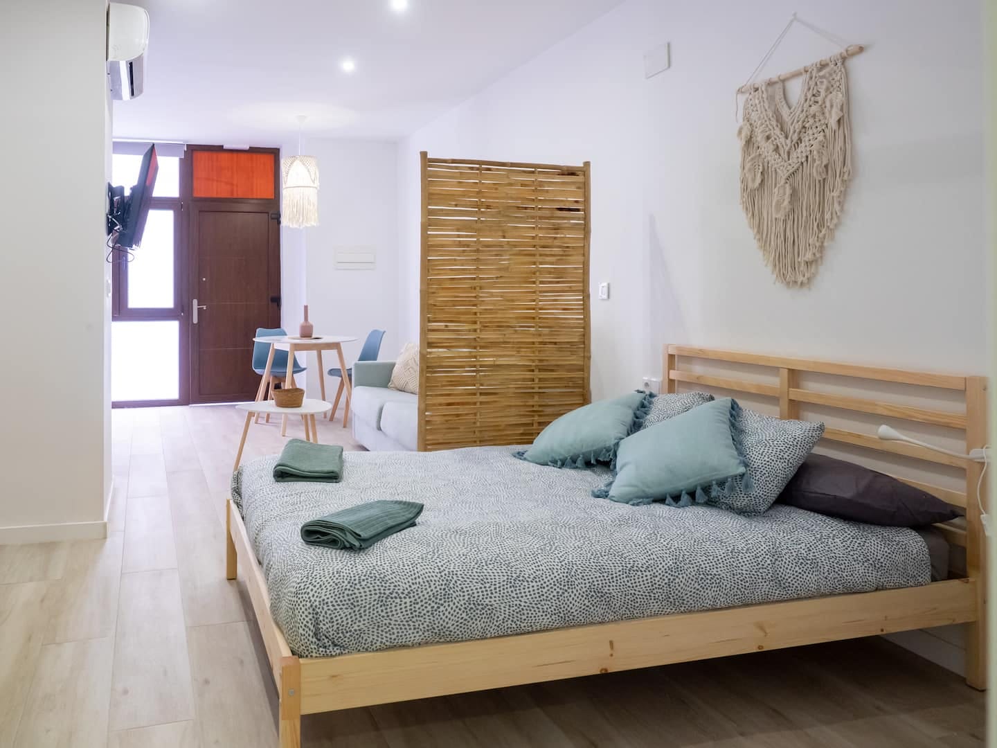 Vista completa del estudio: cama doble, biombo y entrada desde la calle